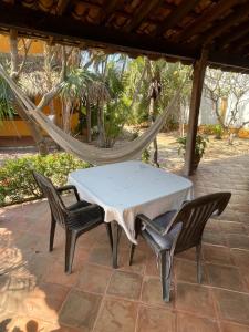 a table and chairs on a patio with a hammock at Habitacion Sol in Puerto Escondido