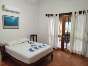 a bedroom with a bed and a sliding glass door at Habitacion Sol in Puerto Escondido