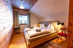 a bedroom with a bed and a window at Marktlhütte in Hochrindl