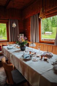 a table with a white table cloth and flowers on it at Marktlhütte in Hochrindl