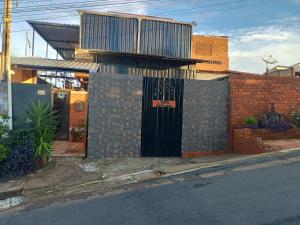 a building with a gate with a balcony on top of it at Pousada Casa Jardim in Serra Negra