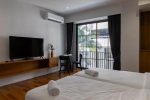a hotel room with two beds and a flat screen tv at Q Space Sathorn - Narathiwas 18 in Ban Nong Chaeng +110 photos