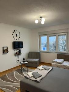 a living room with a couch and a clock on the wall at Apartman Spaja in Trebinje