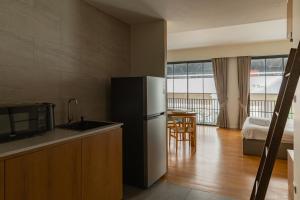 a kitchen with a refrigerator and a room with a bed at Q Space Sathorn - Narathiwas 18 in Ban Nong Chaeng