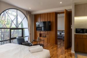 a hotel room with a bed and a large window at Q Space Sathorn - Narathiwas 18 in Ban Nong Chaeng