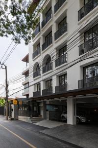 a large white building with balconies on a street at Q Space Sathorn - Narathiwas 18 in Ban Nong Chaeng