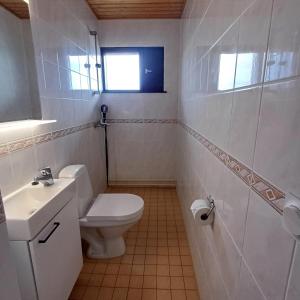 a white bathroom with a toilet and a sink at Hotel Sommarvind in Inkoo +31 photos