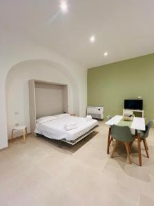 a bedroom with a bed and a desk and a computer at In Villa - Dimora Liberty in Gravina in Puglia