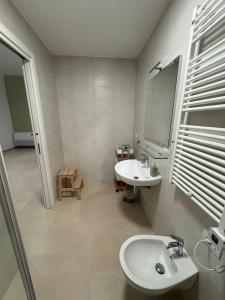 a bathroom with two sinks and a mirror at In Villa - Dimora Liberty in Gravina in Puglia +10 photos