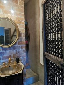 a bathroom with a sink and a mirror at Côté fontaine in Orange