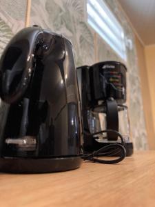 a black coffee maker sitting on top of a table at Le Secret de Grippon in Morne-à-lʼEau