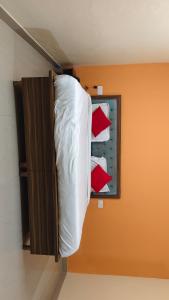 a bed in a room with red and white pillows at Hotel R Himalayan in Mohali