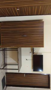 a large wooden cabinet in a room with a tv at Hotel R Himalayan in Mohali +2 photos
