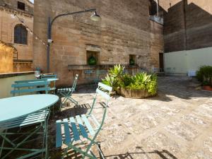 a patio with chairs and tables in a brick building at Moro Guest House in Lecce