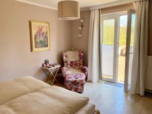 a bedroom with a bed and a chair and a window at Apartment am Golfplatz in Obernkirchen