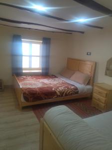a bedroom with a large bed and a window at Maison Ighrem in Idoukaln