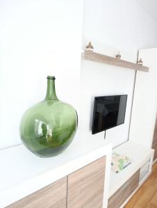a large green glass vase sitting on a counter at La Escapada, muy cerca de Llanes in Llanes