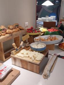 a table with cheese and other food on display at Hotel Carol & Residence Grazia in Rimini