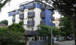 a building with blue balconies on the side of it at Hotel Carol & Residence Grazia in Rimini