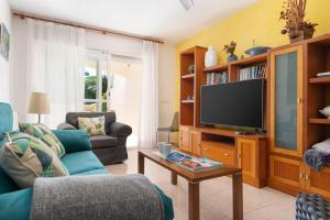a living room with a blue couch and a tv at Villa El Olivo in Pollença