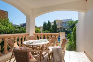 a patio with a table and chairs on a balcony at Villa El Olivo in Pollença