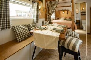 a dining room with a table and a bedroom at Camping la Tamarissière in Agde +125 photos