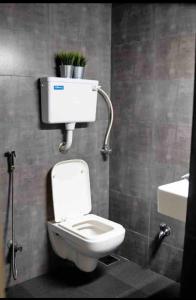 a bathroom with a toilet with a plant on the wall at Cosy studio at Delphi bungalow in Mumbai