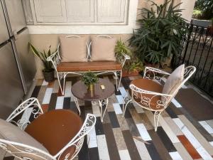 a balcony with chairs and a table and a couch at Cosy studio at Delphi bungalow in Mumbai +9 photos