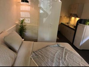 a living room with a couch and a kitchen at Cosy studio at Delphi bungalow in Mumbai
