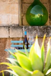 a bottle of wine sitting on a bench next to a plant at Moro Guest House in Lecce