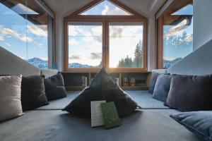 a room with a couch with pillows and a large window at Berghotel Predigstuhl in Bad Goisern