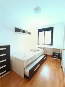 a white bedroom with a bed and a window at La Escapada, muy cerca de Llanes in Llanes