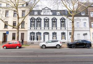 three cars parked in front of a white building at Boutique Apartment 74 in Krefeld