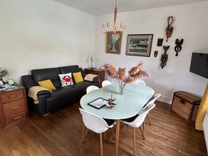 a living room with a table and a couch at Le numéro 5 in Bar-le-Duc