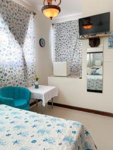 a bedroom with a bed and a chair and a table at The Boat House in Boca Chica