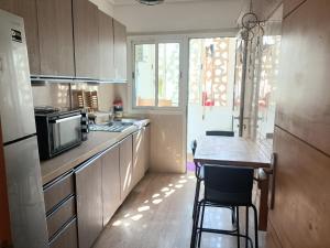a kitchen with a counter with a microwave and a table at Cosy appart 3p in Rabat
