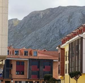 a mountain in the background of a city with buildings at La Escapada, muy cerca de Llanes in Llanes