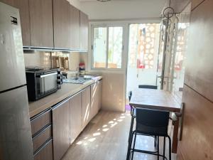 a kitchen with a microwave and a counter with chairs at Cosy appart 3p in Rabat +15 photos