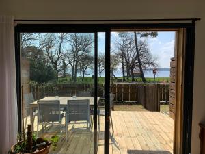 a sliding glass door to a patio with a table and chairs at Le Moutchic in Lacanau +5 photos
