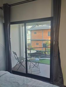 a bedroom with a view of a balcony with a table and chairs at Berlin Haus - CONSTRUCTION มีการก่อสร้าง - LOUD NOISE in Nonthaburi
