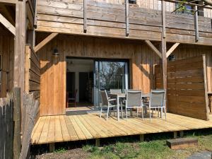 a wooden deck with a table and chairs on it at Le Moutchic in Lacanau