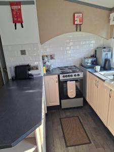 a kitchen with a stove and a counter top at No 1 The Glen in Port Seton