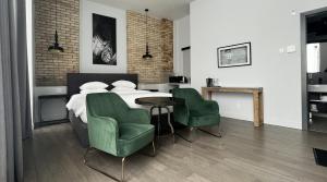 ein Schlafzimmer mit einem Bett und zwei grünen Stühlen in der Unterkunft Hotel Oui GO! in Trois-Rivières