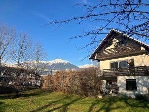 a house with snow covered mountains in the background at Apartments Lajk in Lesce
