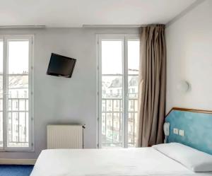 a bedroom with a bed and a tv on the wall at Hotel Royal Mansart in Paris +5 photos