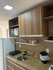 a kitchen with a sink and a refrigerator at Boulevard Plaza Flat Mirante Apto 201 in Campina Grande +2 photos