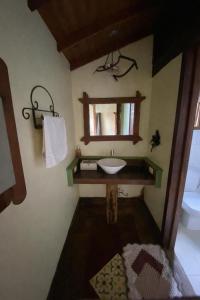 a bathroom with a sink and a mirror at Chalé Bougainville in Lavras Novas +22 photos