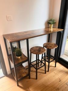 a wooden table with two stools in a room at Studio élégant et indépendant Centre ville - Quartier facultés in Nantes