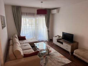 a living room with a couch and a tv at Podgorica Royal Apartment in Podgorica