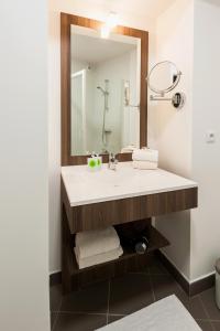 a bathroom with a sink and a mirror at Ténéo Apparthotel Talence Espeleta - Bordeaux Sud in Talence +27 photos